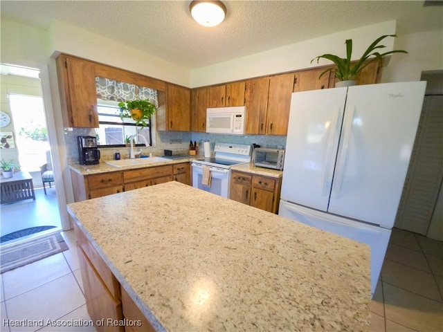 1503 Goldbud St, Lake Placid, FL 33852 - kitchen featuring white appliances, a sink, brown cabinets, and light tile patterned flooring