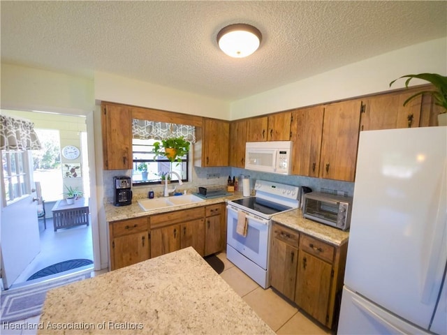 1503 Goldbud St, Lake Placid, FL 33852 - kitchen featuring brown cabinets, a textured ceiling, a sink, and white appliances