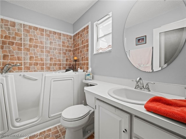 bathroom featuring tile patterned flooring, vanity, toilet, and a textured ceiling