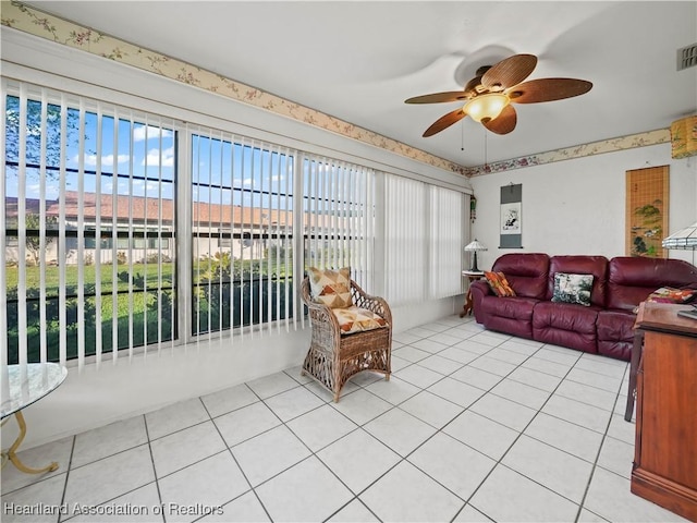 living room featuring ceiling fan, light tile patterned floors, and a healthy amount of sunlight