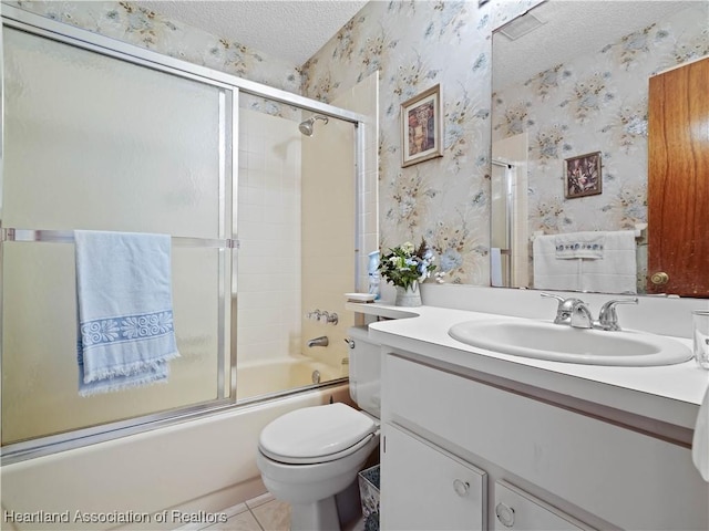 full bathroom with tile patterned flooring, bath / shower combo with glass door, a textured ceiling, toilet, and vanity