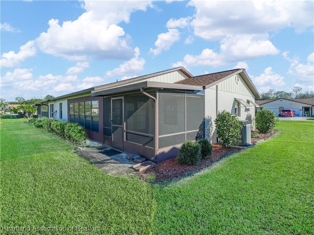 view of side of home with a yard and a sunroom