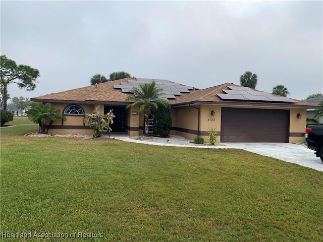 single story home with an attached garage, solar panels, concrete driveway, stucco siding, and a front yard