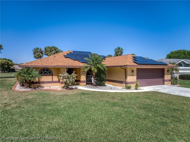 single story home featuring stucco siding, roof mounted solar panels, a garage, and a front lawn