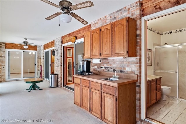 kitchen with ceiling fan, sink, and brick wall