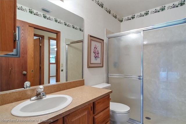 bathroom with vanity, toilet, and walk in shower