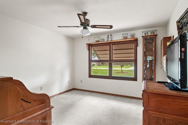 living area featuring light carpet and ceiling fan