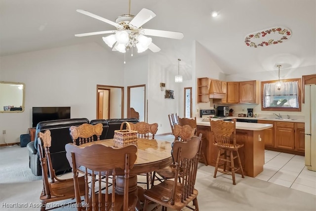 tiled dining space featuring high vaulted ceiling, ceiling fan, and sink