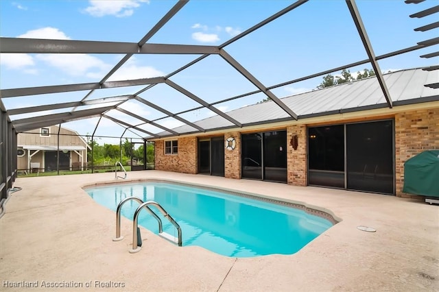 view of swimming pool with a lanai, a patio, and grilling area