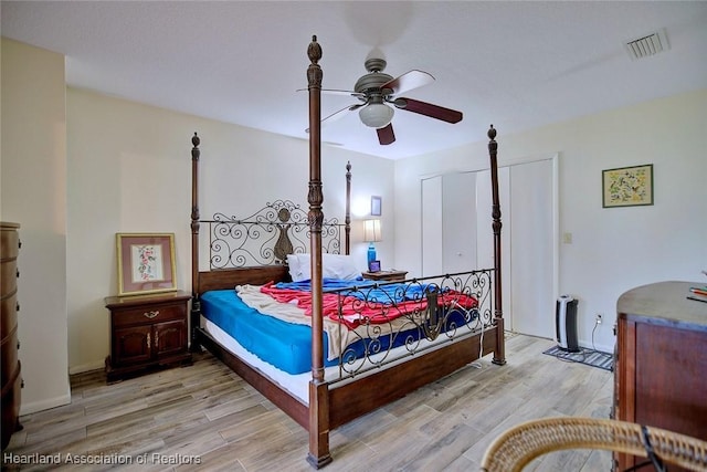 bedroom featuring light wood-style floors, a closet, visible vents, and ceiling fan