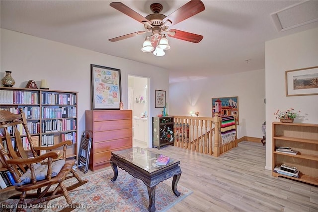 interior space featuring light wood finished floors, attic access, an upstairs landing, and baseboards