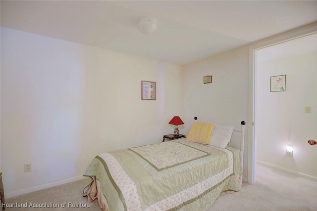 bedroom featuring light carpet and baseboards