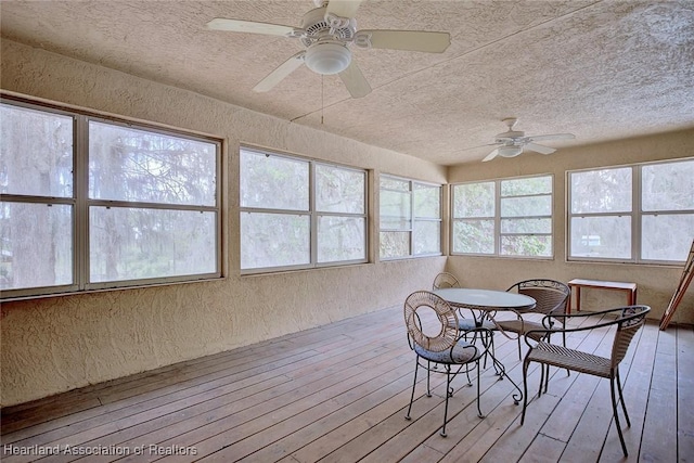 unfurnished sunroom featuring a ceiling fan