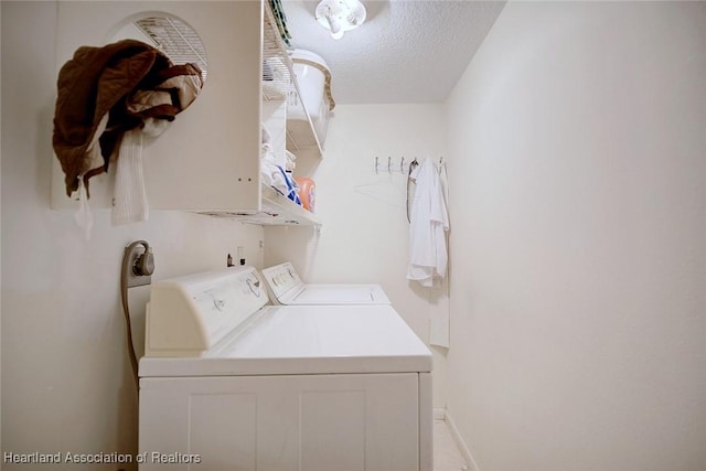 laundry room featuring laundry area, a textured ceiling, baseboards, and separate washer and dryer