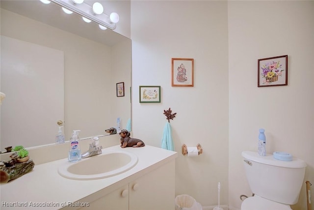 half bath featuring vanity and toilet