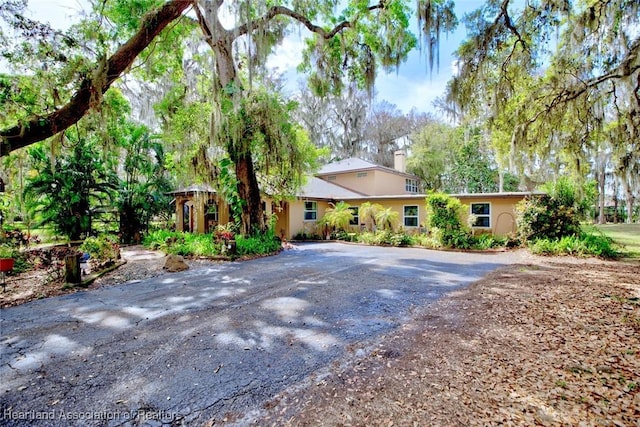 ranch-style house featuring driveway and a chimney