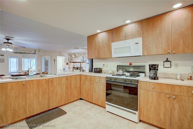 kitchen featuring range with gas stovetop, recessed lighting, light countertops, white microwave, and a ceiling fan