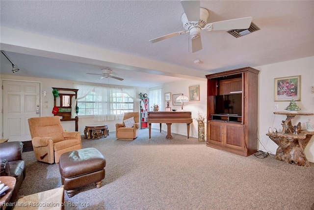 living area featuring a textured ceiling, ceiling fan, carpet, and visible vents