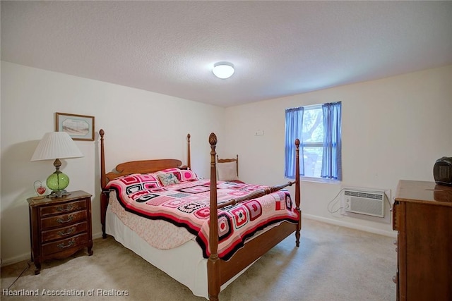 bedroom with light colored carpet, a wall unit AC, a textured ceiling, and baseboards