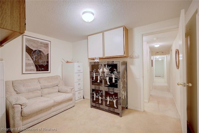 living room featuring light carpet, a textured ceiling, and baseboards