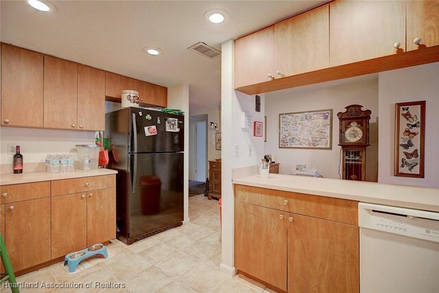 kitchen with white dishwasher, recessed lighting, visible vents, light countertops, and freestanding refrigerator