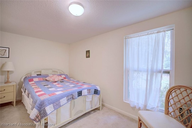bedroom with a textured ceiling, carpet, and baseboards