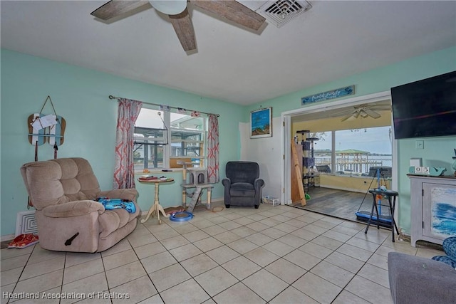 living area featuring ceiling fan, baseboards, tile patterned floors, and visible vents