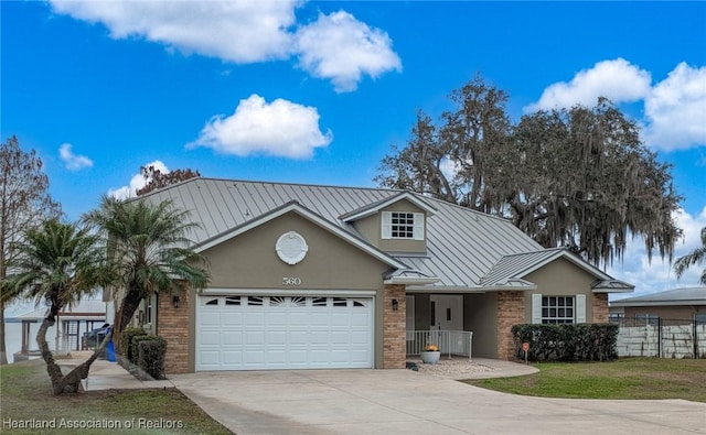 560 Lake June Rd, Lake Placid, FL 33852 - view of front of house with brick siding, concrete driveway, a standing seam roof, and metal roof