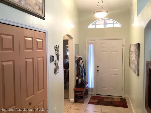 entrance foyer featuring a towering ceiling and light tile patterned flooring