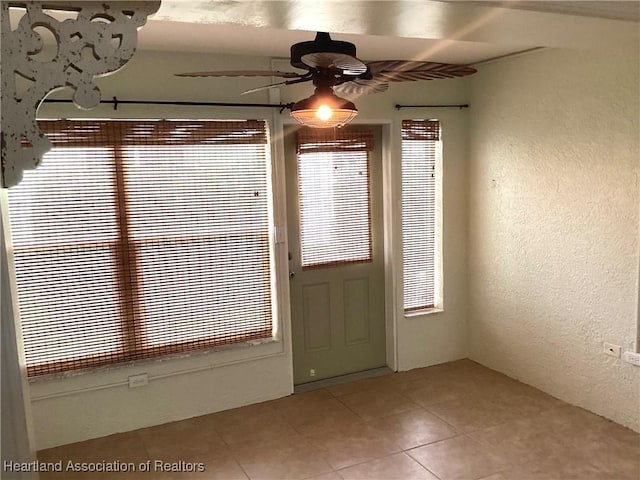 entryway with ceiling fan and tile patterned floors