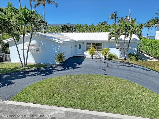 115 Elwa Pl, West Palm Beach, FL 33405 - single story home featuring an attached garage, driveway, a front yard, stucco siding, and a tile roof