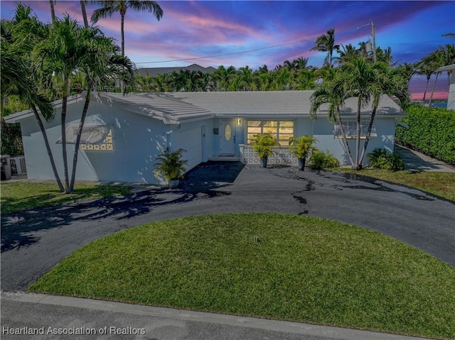 115 Elwa Pl, West Palm Beach, FL 33405 - single story home featuring an attached garage, asphalt driveway, stucco siding, and a front yard