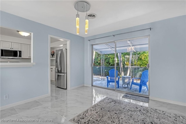 115 Elwa Pl, West Palm Beach, FL 33405 - kitchen with stainless steel appliances, light marble finish flooring, decorative light fixtures, light countertops, and white cabinetry