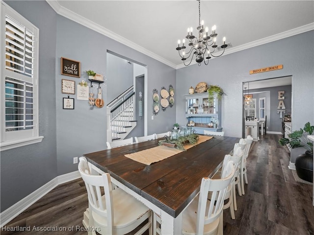 dining space featuring dark hardwood / wood-style flooring, an inviting chandelier, and ornamental molding