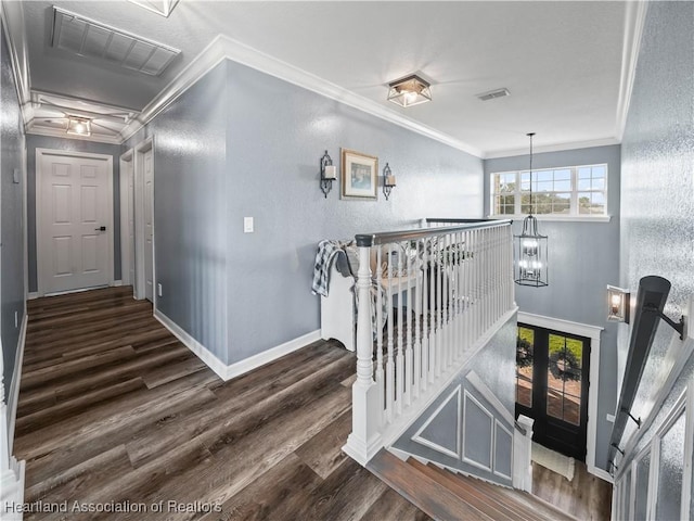 stairway featuring ornamental molding, hardwood / wood-style flooring, and a notable chandelier