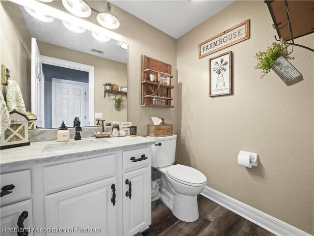 bathroom featuring toilet, wood-type flooring, and vanity