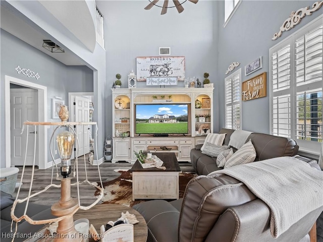 living room with an inviting chandelier, dark hardwood / wood-style flooring, and a high ceiling