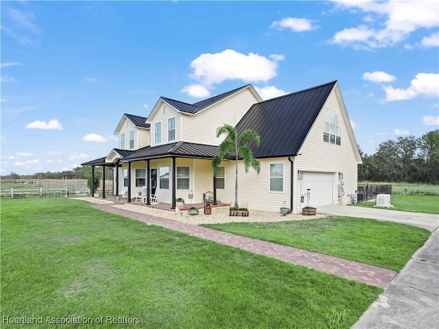 view of front of property with a front yard, covered porch, and a garage