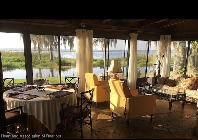 sunroom / solarium featuring a water view