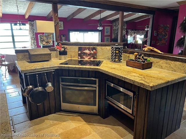 kitchen featuring appliances with stainless steel finishes, beam ceiling, hanging light fixtures, and a center island