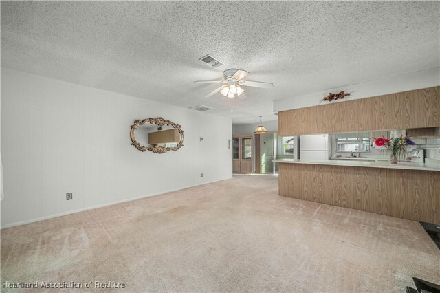 170 Parkview Cir, Lake Placid, FL 33852 - unfurnished living room with a ceiling fan, light carpet, a textured ceiling, and baseboards
