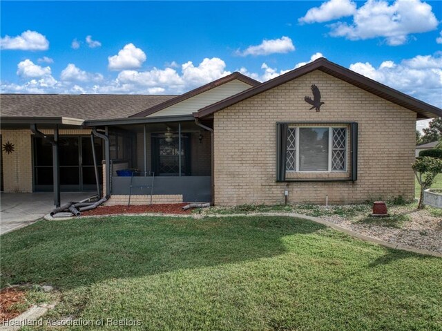 170 Parkview Cir, Lake Placid, FL 33852 - ranch-style house with a front yard, brick siding, a sunroom, and ceiling fan