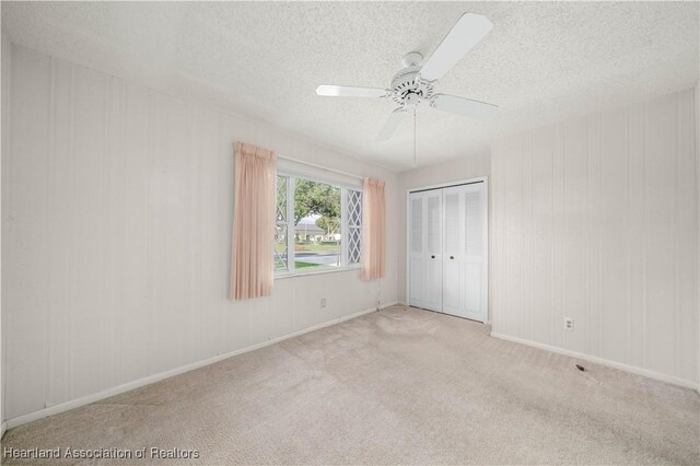 170 Parkview Cir, Lake Placid, FL 33852 - unfurnished bedroom featuring a textured ceiling, carpet flooring, a closet, a ceiling fan, and baseboards