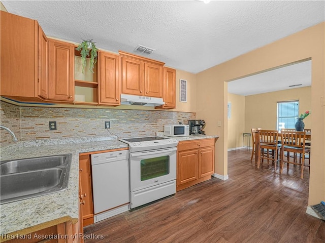 1621 Warfield Pl, Sebring, FL 33870 - kitchen featuring white appliances, under cabinet range hood, dark wood-type flooring, light countertops, and a textured ceiling