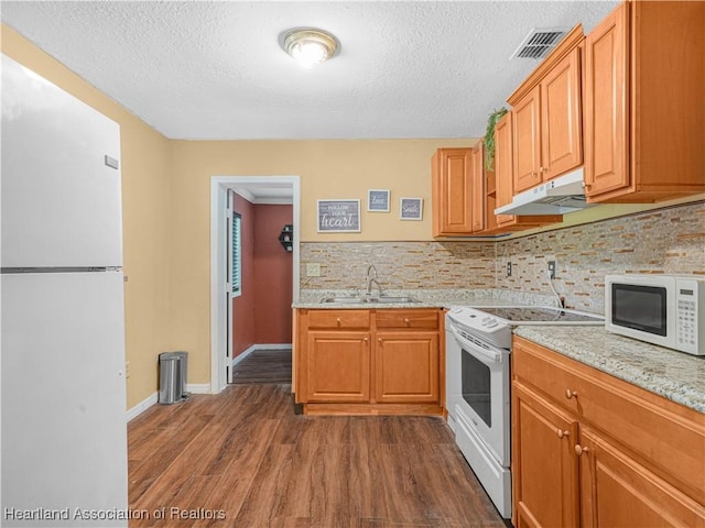 1621 Warfield Pl, Sebring, FL 33870 - kitchen featuring white appliances, under cabinet range hood, dark wood finished floors, a textured ceiling, and decorative backsplash