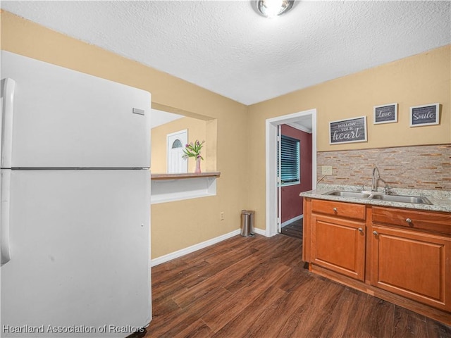 1621 Warfield Pl, Sebring, FL 33870 - kitchen featuring freestanding refrigerator, dark wood-style flooring, light countertops, a textured ceiling, and brown cabinets