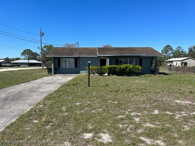 ranch-style home featuring fence, a front yard, and concrete driveway
