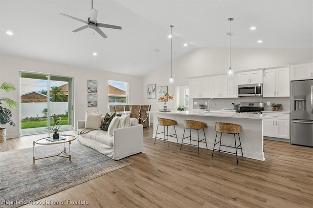 4954 San Ignacio Dr, Sebring, FL 33872 - living room with high vaulted ceiling, recessed lighting, light wood-style flooring, and ceiling fan