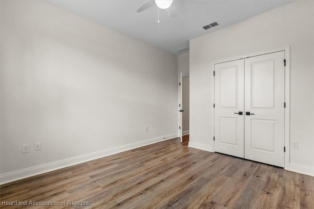 4954 San Ignacio Dr, Sebring, FL 33872 - unfurnished bedroom featuring wood finished floors, ceiling fan, and a closet