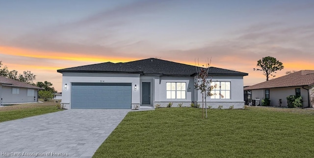 view of front of property with a garage, a lawn, and central air condition unit